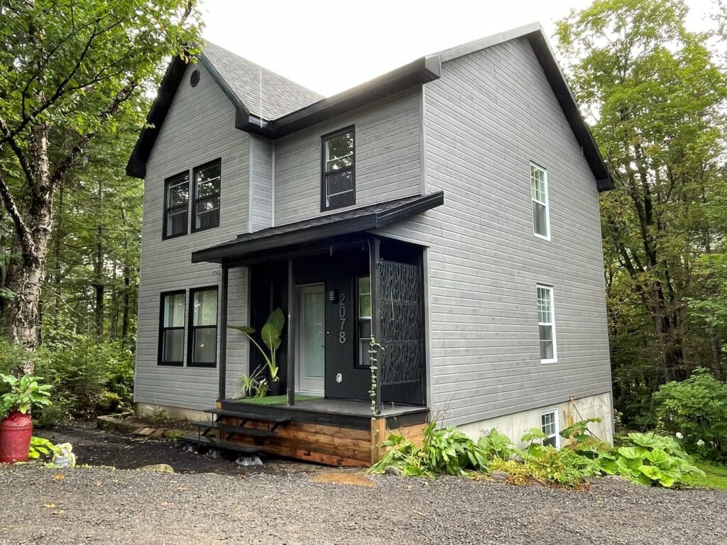 Après — maison agrandie avec nouveau revêtement et portique