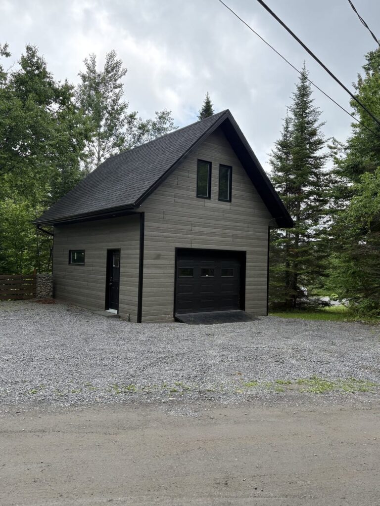 Garage détaché avec revêtement de bois noir et toiture à pignon