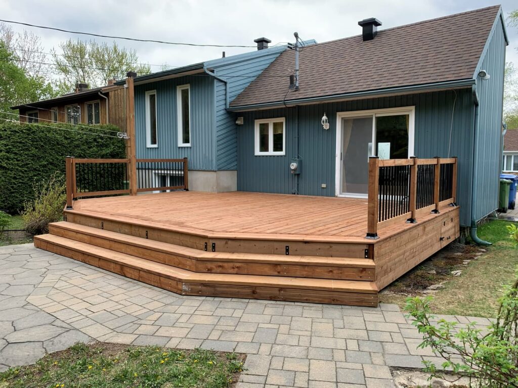 Grande terrasse en bois aménagée à l'arrière d'une maison